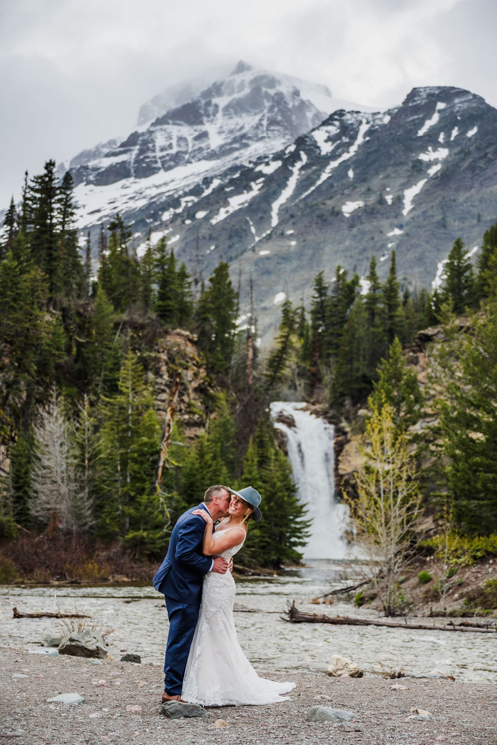 Groom kissing Bride at Running Eagle Falls during elopement in Glacier National Park.