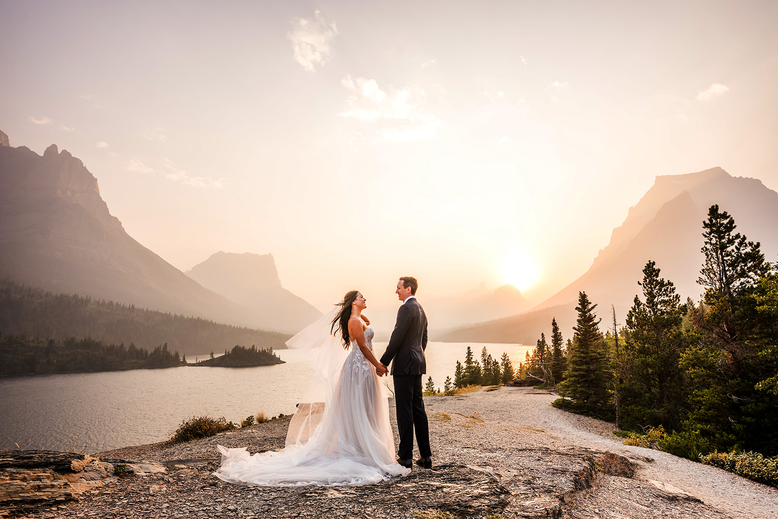 Bride and Groom holding hands during sunset at Sun Point in Glacier National Park.